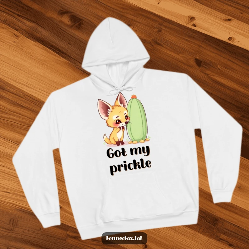 Funny fennec fox hoodie showing a happy character curiously sniffing a large, whimsical cactus, perfect for cozy desert adventures.